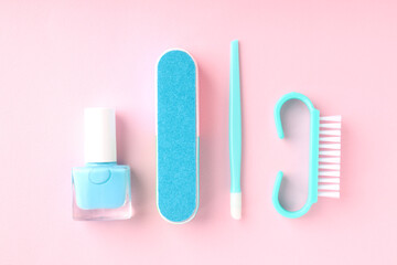 Concept of nail care with manicure accessories on pink background