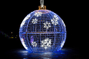 Large Christmas ball on the street in the light of night lights