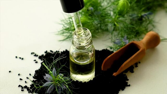 Black cumin oil in a bottle. Selective focus.