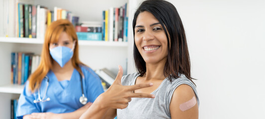Pretty latin american woman after third vaccination against Covid 19 with nurse
