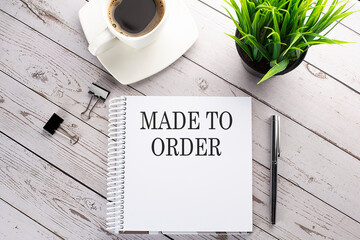 Cofee cup, notepad,pen on the wooden background. Business concept. Text MADE TO ORDER