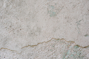 An empty concrete surface with cracks and traces of old paint. The background is a painted old wall. A place to insert text or design.
