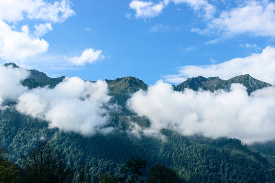 Thick white clouds float in the mountains. Beautiful mountain landscape. Nature background 