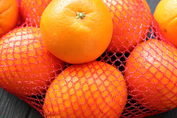 many fresh oranges in a red net 
