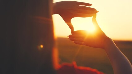 silhouette girl making frame with hands the sun outdoors in the park. travel freedom a concept. people in the park. close-up girl makes a frame with her hands imitates a photo sunlight