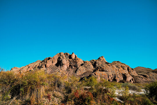 A beautiful view of the red rocky mountain on the contrasting blue sky background.