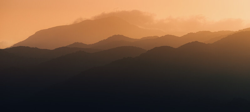 Panoramic and mood atmospheric silhouette of the mountain ridge at sunset