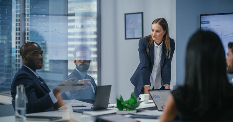 Diverse Office Conference Room Meeting: Motivated Female Digital Startup Owner Presents e-Commerce Fintech Growth Statistics to a Group of Investors. Wall TV with Big Data Analysis, Infographics