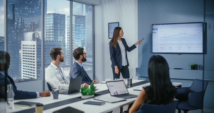 Diverse Office Conference Room Meeting: Successful Female Executive Director Presents e-Commerce Fintech Growth Statistics to a Group of Investors. Wall TV with Big Data Analysis, Infographics