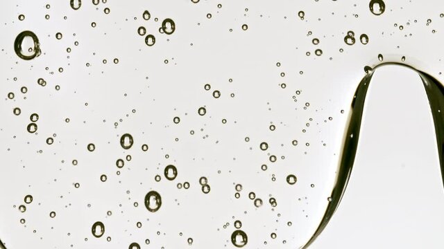 Transparent Cosmetic Gel Fluid With Molecule Bubbles Flowing On The Plain Surface. Macro Shot. High quality 4k footage