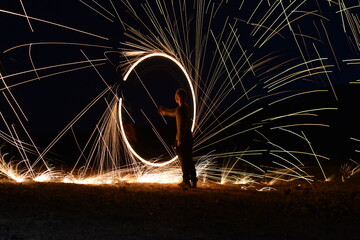 Iron wool circle drawing light fireworks. Burning Steel Wool spinning, Trajectories of burning sparks at night. Movement light effect, steel wool fire hoop. long exposure light painting, Pyrotechnic