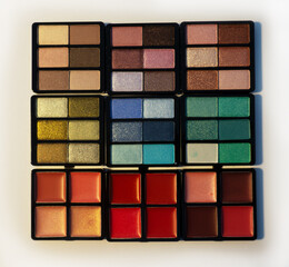 Large set of cosmetics. Eyeshadows and lip glosses. View from above. Isolated image on a white background. Nobody. New cosmetics.