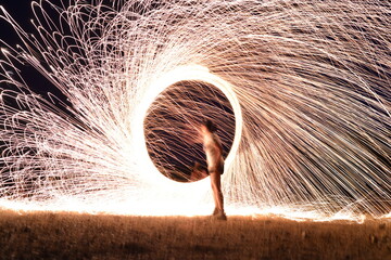 Iron wool circle drawing light fireworks. Burning Steel Wool spinning, Trajectories of burning sparks at night. Movement light effect, steel wool fire hoop. long exposure light painting, Pyrotechnic