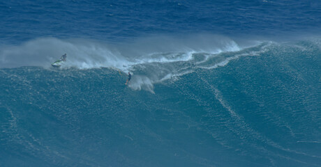 Fototapeta premium Sport photography. Jaws swell on International surfing event in Maui, Hawai 2021 December.