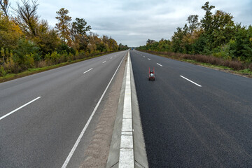 New and old road divided by a dividing strip New Jersey. Road construction.