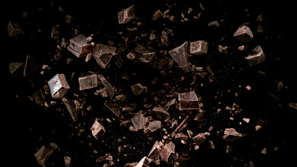 Freeze motion of flying group of raw chocolate pieces.
