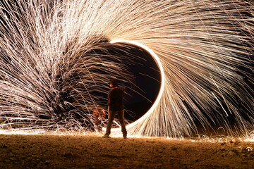 Iron wool circle drawing light fireworks. Burning Steel Wool spinning, Trajectories of burning sparks at night. Movement light effect, steel wool fire hoop. long exposure light painting, Pyrotechnic