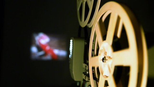 Close-up of an old movie projector shows home filming on film.