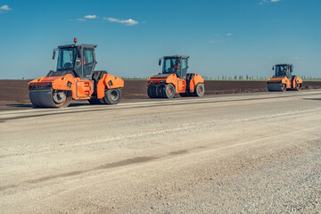 Rollers compacts a fresh layer of concrete mix on the road construction
