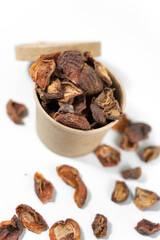 Dried apricots in a paper cup with a lid over white background. Top view.