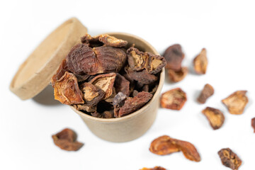 Dried apricots in a paper cup with a lid over white background. Top view.