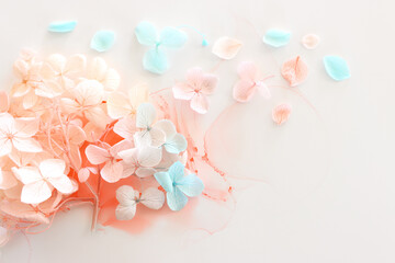 Creative image of pastel blue and pink Hydrangea flowers on artistic ink background. Top view with...