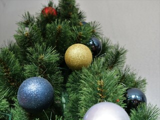 bottom-up view of a decorated artificial pine tree with balls of different colors as a New Year or Christmas texture background, a fragment of a festive decor during the winter holidays