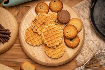 Homemade butter cookies and chocolate chip cookies and stick biscuits on wooden background ready to serve as snacks with tea and coffee on happy time.  