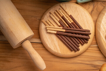 Chocolate stick biscuits on wooden background ready to serve as snacks with tea and coffee on happy time.  