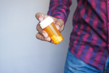 young man hand holding medicine pill container 