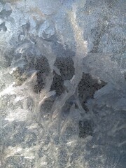 Frosty pattern on the window. Frozen glass, illuminated by the sun.