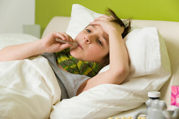 Junge mit Fieber im Bett