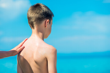 A parent smears a child with sunscreen. Sun protection. Preventing sunburn. Baby cream