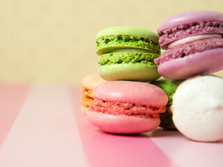 Fresh baked colored macaroon cookies macarons, macarons on a white plate close-up,