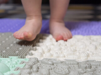 baby's feet on a children's orthopedic mat close-up