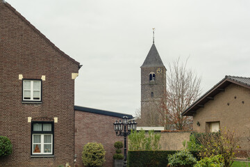 Fototapeta na wymiar Two houses and a church in a rural village under a cloudy sky.