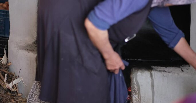 Female making bread In the oriental courtyard. Lit the firewood to bake bread