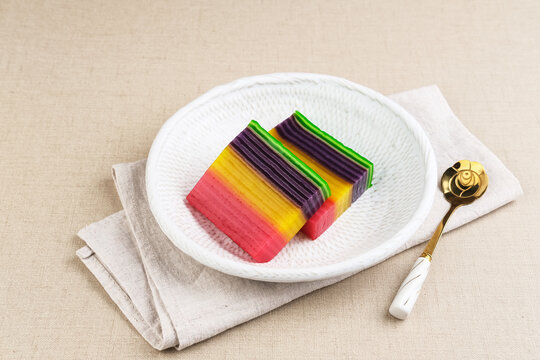 Kue Lapis or Kue Pepe or Rainbow sticky layer cake, Indonesian traditional dessert made from rice flour and coconut milk, steamed layer by layer. Served in white plate, copy space. Selective focus.
