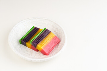 Kue Lapis or Kue Pepe or Rainbow sticky layer cake, Indonesian traditional dessert made from rice flour and coconut milk, steamed layer by layer. Served in white plate, copy space. Selective focus.
