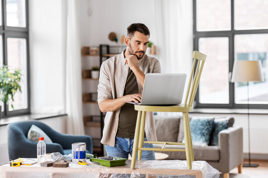 Furniture Restoration, Diy And Home Improvement Concept - Man With Laptop Preparing Old Wooden Chair For Renovation