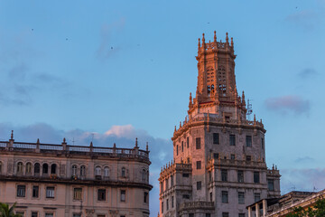 Obraz premium Street scene with classic old cars and traditional colorful buildings in downtown Havana