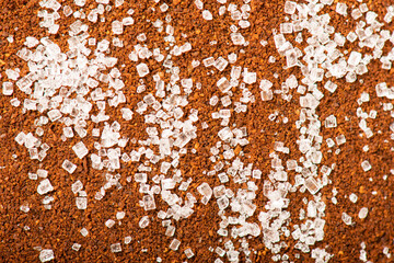 Ground turkish coffee with sugar grains macro textured background.