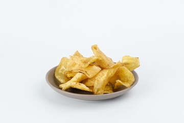 Heap of dried banana chips snack on white background. Selective focus image, blurred background.

