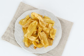 Heap of dried banana chips snack on white background. Selective focus image, blurred background.

