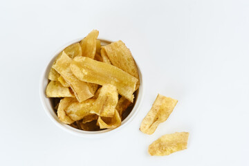 Heap of dried banana chips snack on white background. Selective focus image, blurred background.


