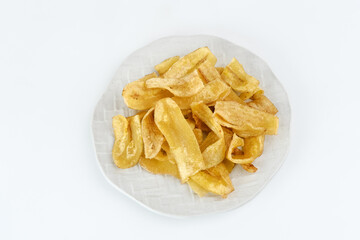 Heap of dried banana chips snack on white background. Selective focus image, blurred background.

