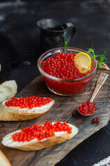Red caviar on a dark background. Sandwiches with caviar