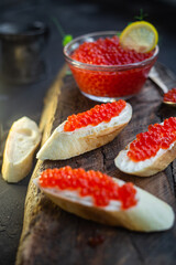 Red caviar on a dark background. Sandwiches with caviar