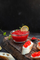 Red caviar on a dark background. Sandwiches with caviar