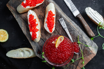 Red caviar on a dark background. Sandwiches with caviar